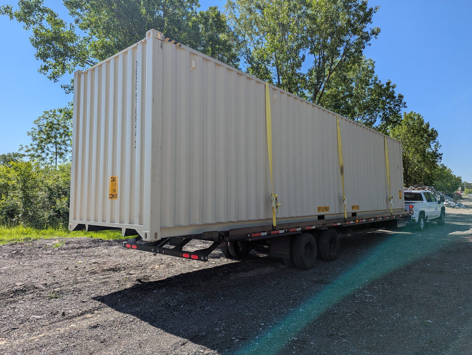Container loaded and strapped onto a flatbed trailer