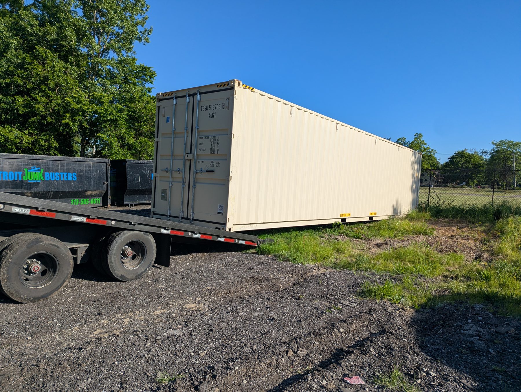 Container being lowered from Atlas Precision Containers flatbed at a depot